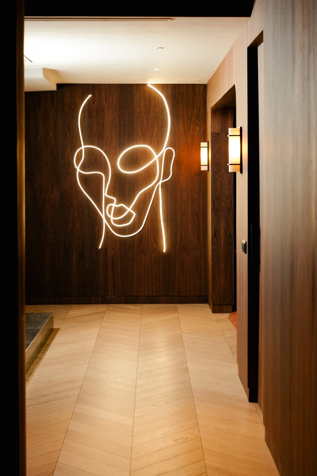 Pasillo con panel de madera y figura iluminada