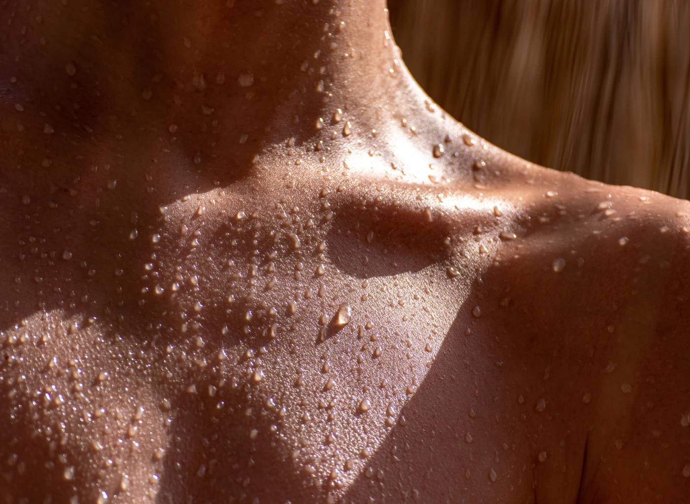Detalle de piel del cuello y el hombro con gotas de agua